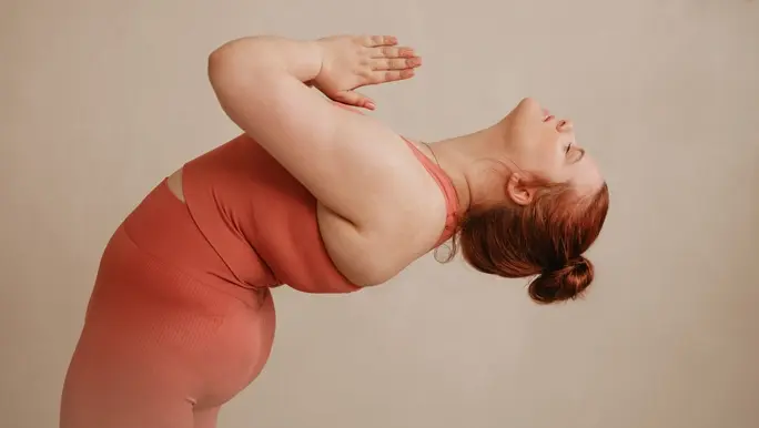 Woman in salmon-pink active wear doing a yoga pose