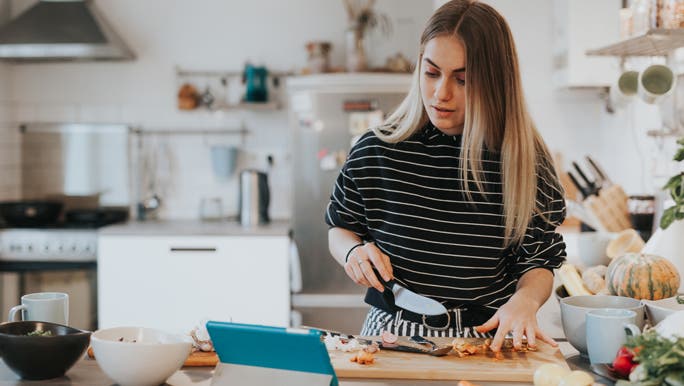 Teenage girl following a recipe on her ipad to make a healthy meal