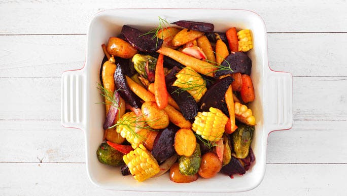 White baking dish filled with colourful roasted vegetables