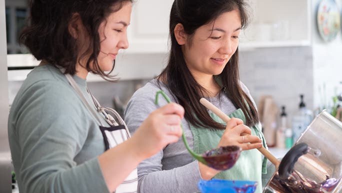 Two women are making preserved food at home which is one of the different ways of processing food.