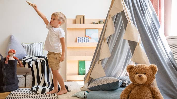 Young boy playing in his minimalist bedroom