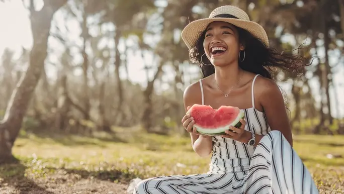 Happy woman eating watermelon outdoors