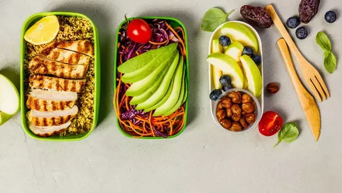 Healthy lunchbox ideas. Chicken and couscous, salad and avocado, berry, apple and nuts