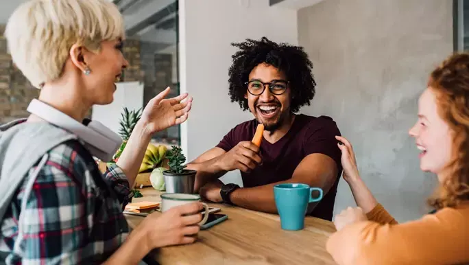 Group of friends sharing a laugh over coffee at home