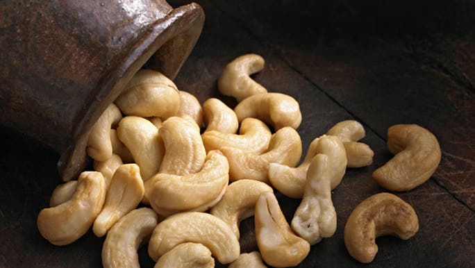 A pile of cashews spill out from a bowl in a house where the resident wonders whether low iron causes headaches.