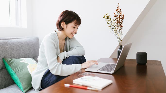 Woman working from home on her laptop at the coffee table