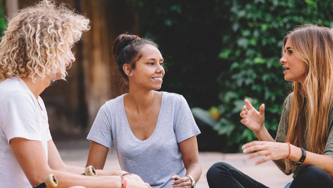 Three university friends sitting in a circle having a conversation