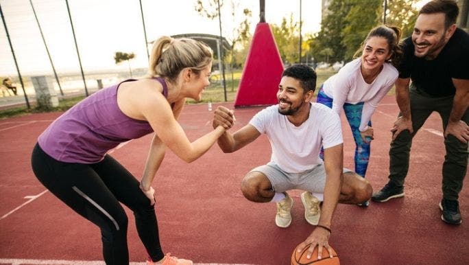 A group of young friends are playing basketball outdoors