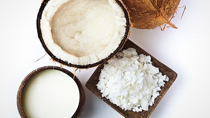 From above, on a white background, different parts of the coconut are displayed together. Is coconut a fruit or a vegetable? 