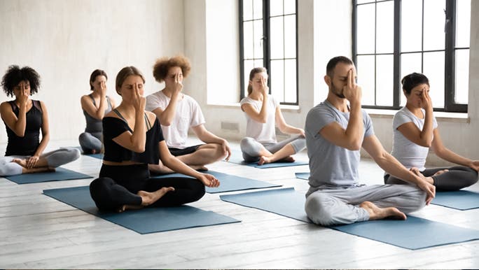 In an exercise class, seven people are experiencing the benefits of meditation and mindfulness.