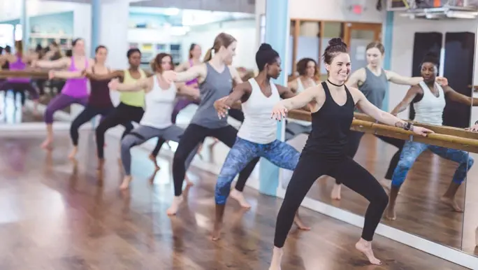 Group of women doing a barre class at the gym