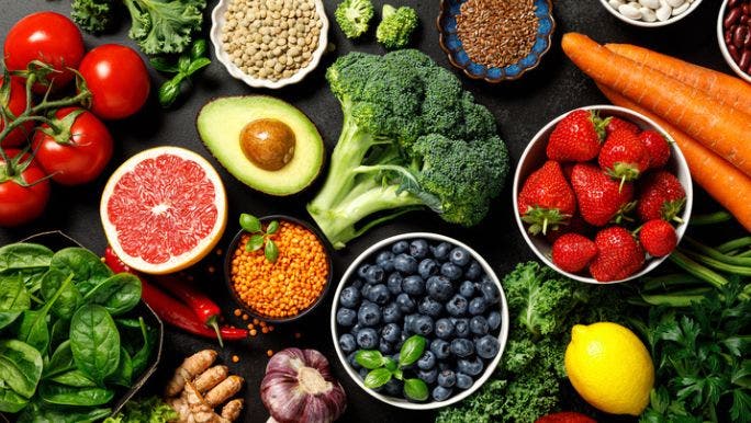 A flat lay photo of fresh fruit and vegetables, which can help the body produce collagen