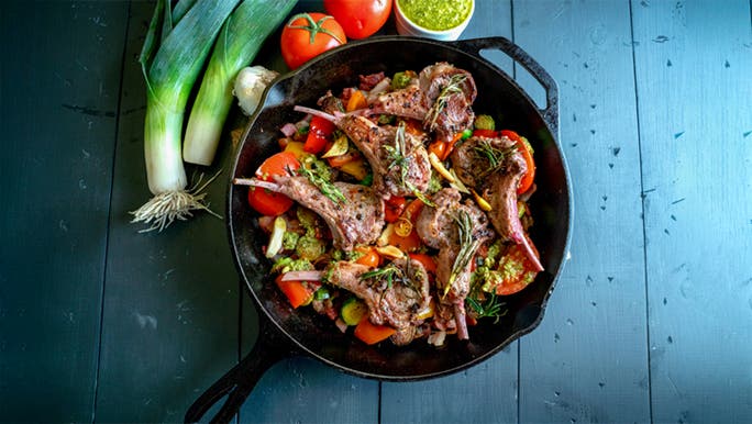 A cast iron pan full of meat and vegetables