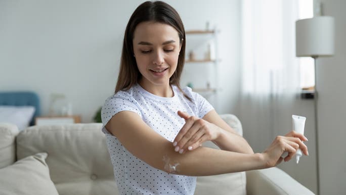 Rubbing moisturiser into her elbow, a woman wonders why her skin is so dry. 