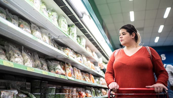 A gorgeous woman shops for vegetables, hopefully, she knows that fad diets don’t work. 