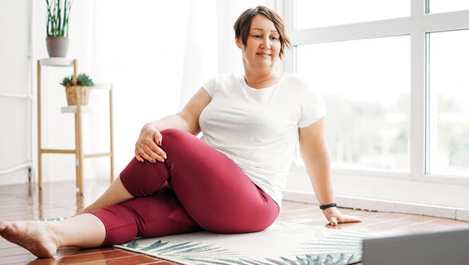 A woman does a short morning stretch yoga session in her home. 