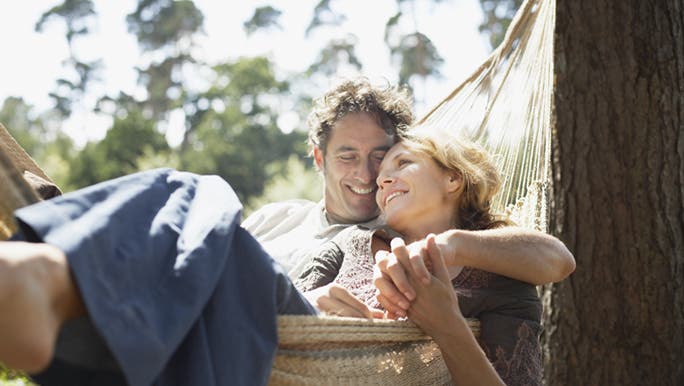 A couple are relaxing together in a hammock. They are still young but thinking about healthy ageing.