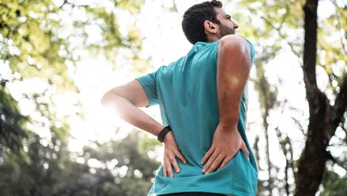 Young sportsman holding his lower back