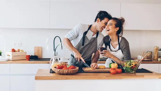 Happy couple making a vegetarian meal in the kitchen