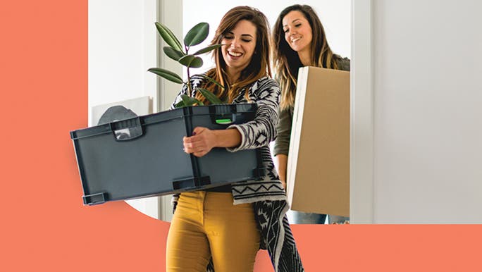 Female couple carrying moving boxes