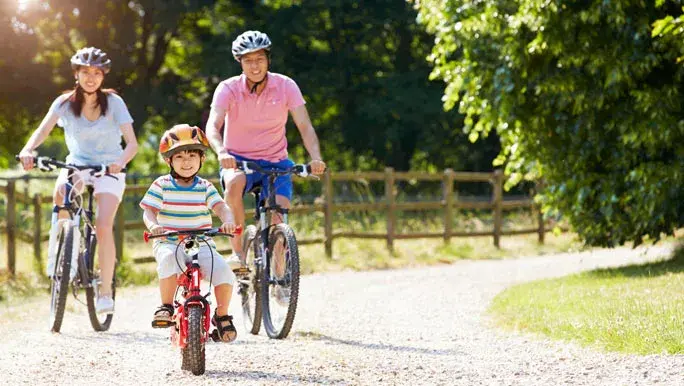 Young boy out bike riding with his mum and dad