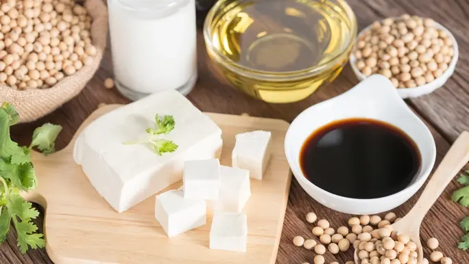 Tofu, soybeans, soy sauce and soy milk on a timber table