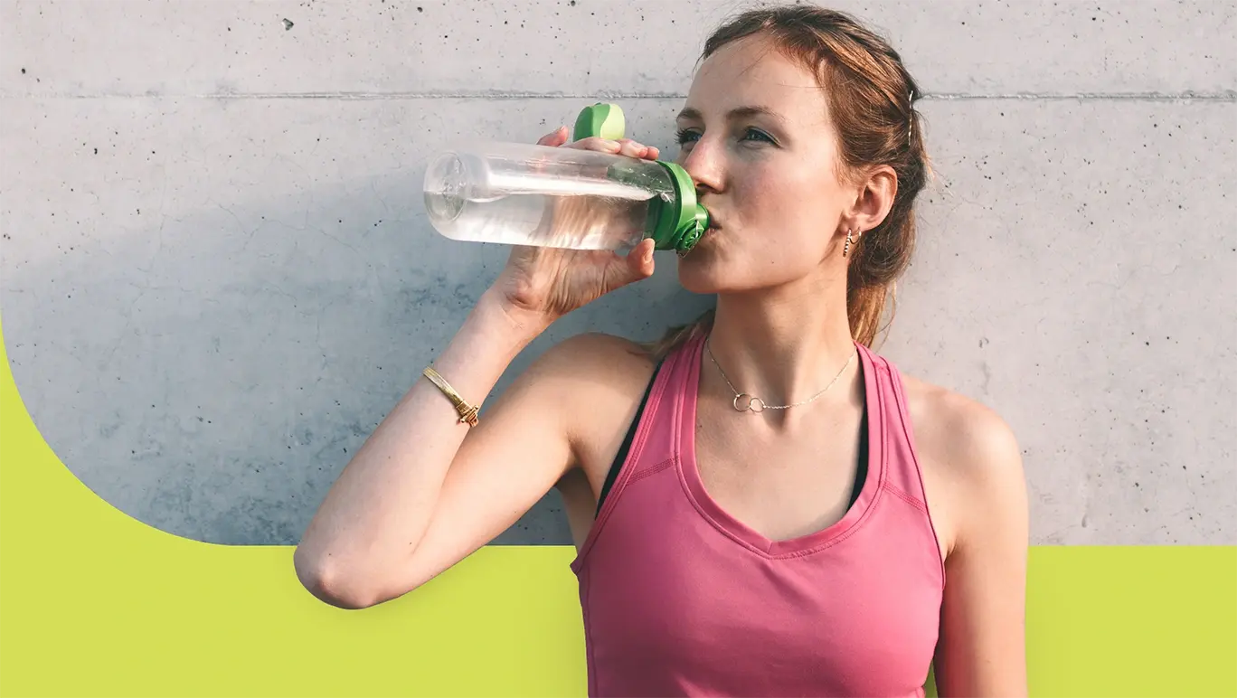 woman wearing a pink shirt drinking water