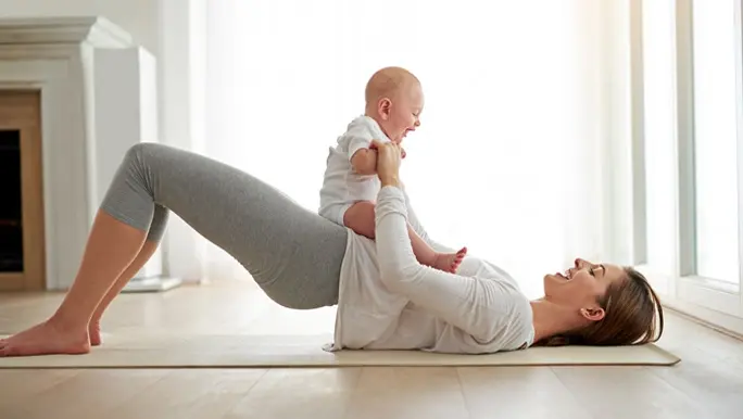 Mum in bridge pose with her happy baby on her belly