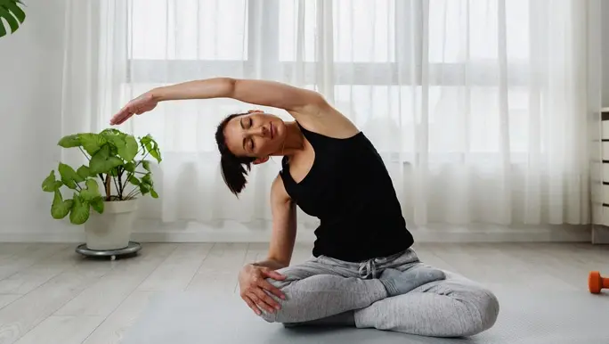 Woman side stretching in lotus yoga pose