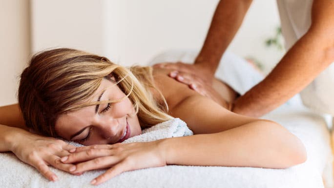 Relaxed woman lying on a massage table having a back remedial massage