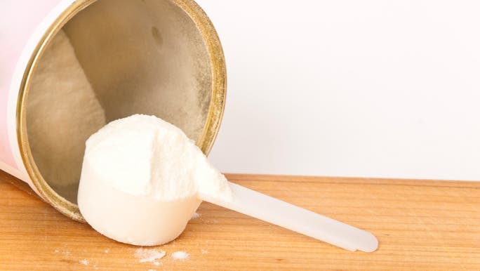 A plastic scoop is filled with a white powdery substance