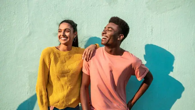 Happy young couple laughing and smiling in the afternoon sun