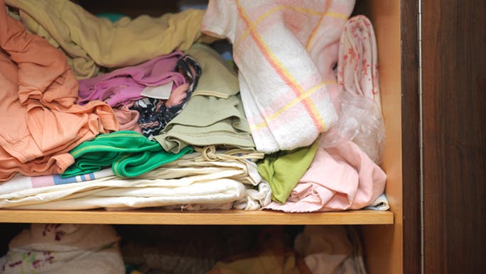 A close-up view point of a linen closet that has not been decluttered in a LONG time.