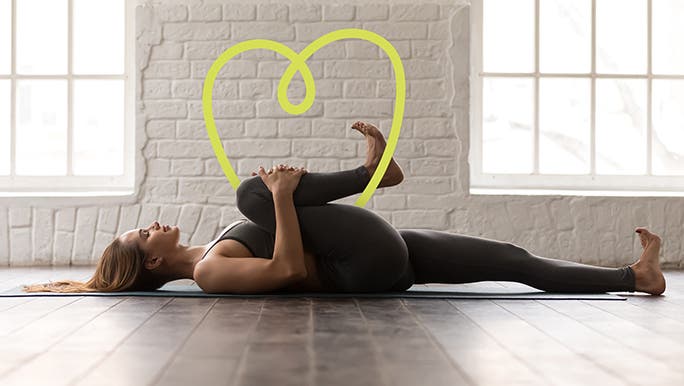 Woman in black active wear stretching in a yoga studio
