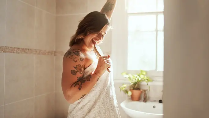 Woman singing into her hairbrush in the bathroom