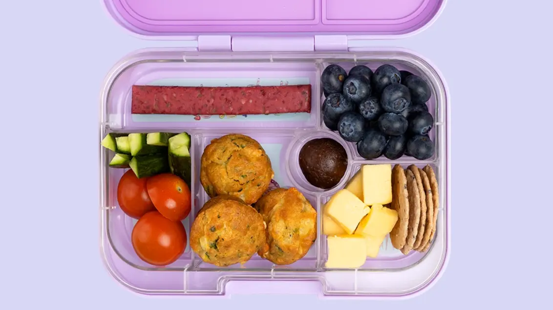 Open lunchbox with a healthy lunch and snacks including strawberry bar from The Mood Food Company