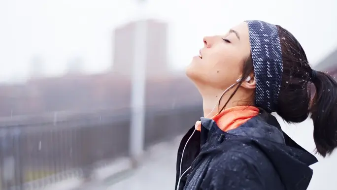 Young woman in navy blue and peach active wear exercising on a cold winter's day