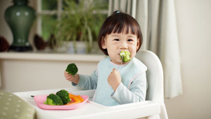 Toddler girl eating her vegetables