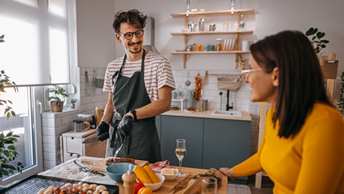 Man and woman cooking in kitchen smiling