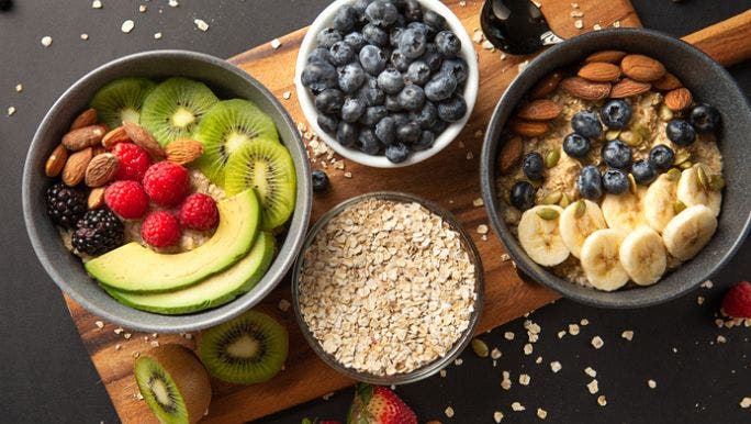 A flat lay image of fruits, vegetables, oats and nuts