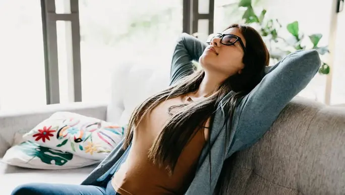 Woman at home leaning back on the couch relaxing