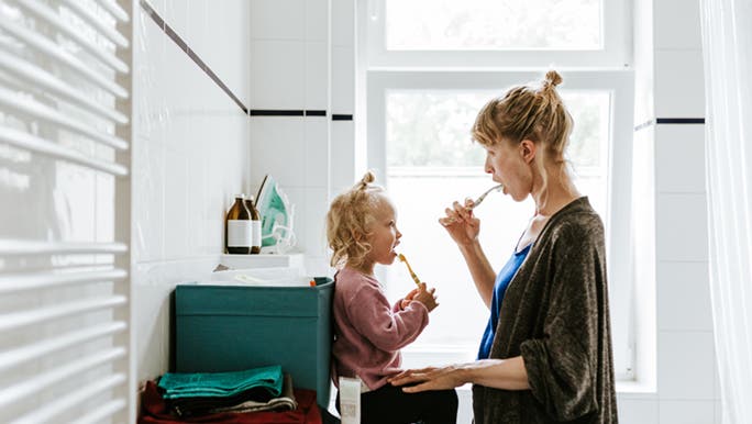 A woman and toddler are brushing their teeth together, mums know how to work smarter, not harder.  