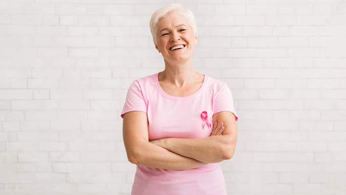Happy woman, smiling,  in a pink t-shirt with a pink breast cancer awareness ribbon