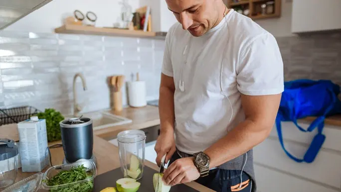 Young man in active wear making a pre workout smoothie