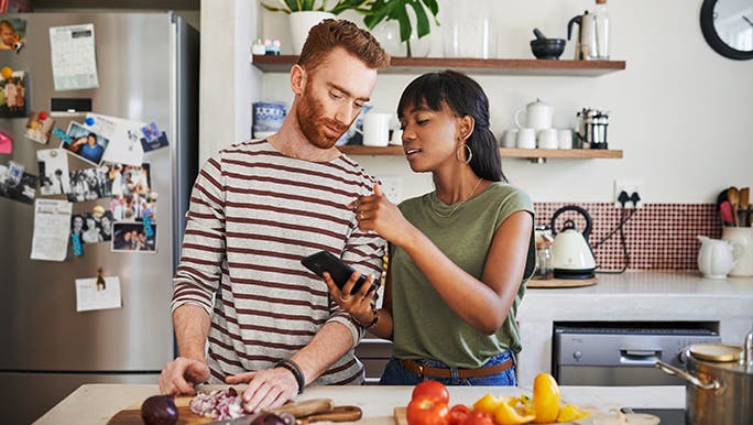 A couple prepare vegan food in a homely kitchen.