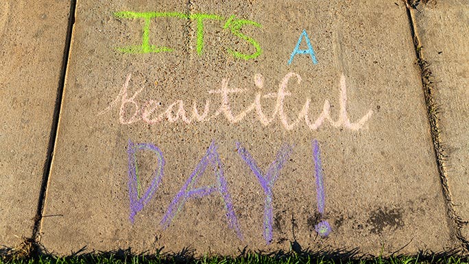 A chalk footpath message with the words "It's a Beautiful Day" written by someone performing an act of kindness while stuck at home. 