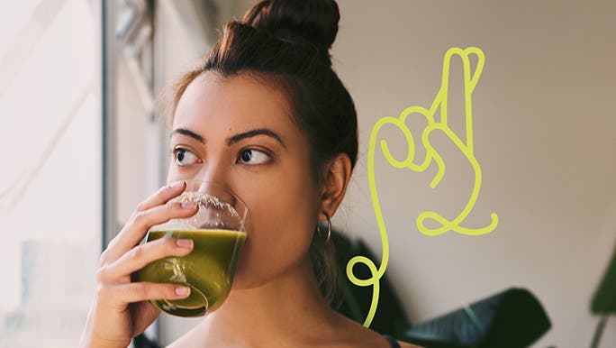 Young woman drinking a fresh green juice first thing in the morning