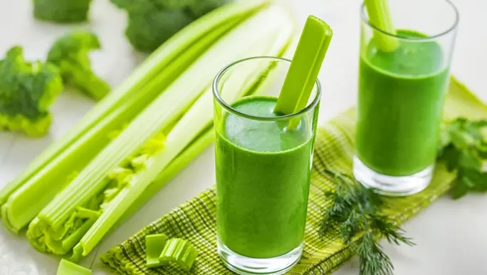 Two glasses of celery juice with fresh celery sticks