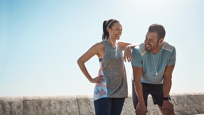 Two people in exercise clothes smiling after they have finished their workout which may have effects on the immune system. 