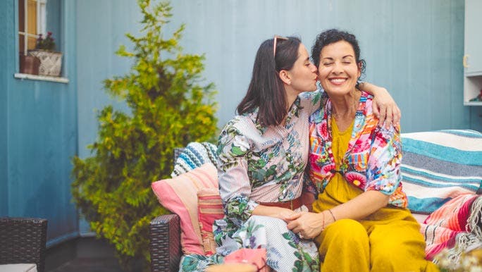 Happy mother and daughter together sitting outside enjoying each others company